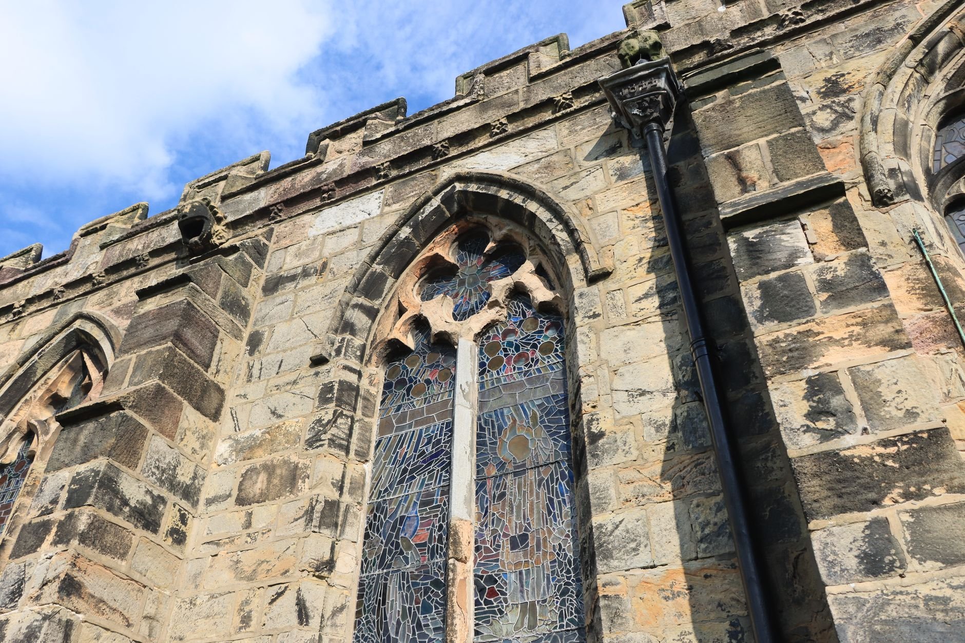 Close-up of a historic Gothic church facade with ornate stained glass windows.